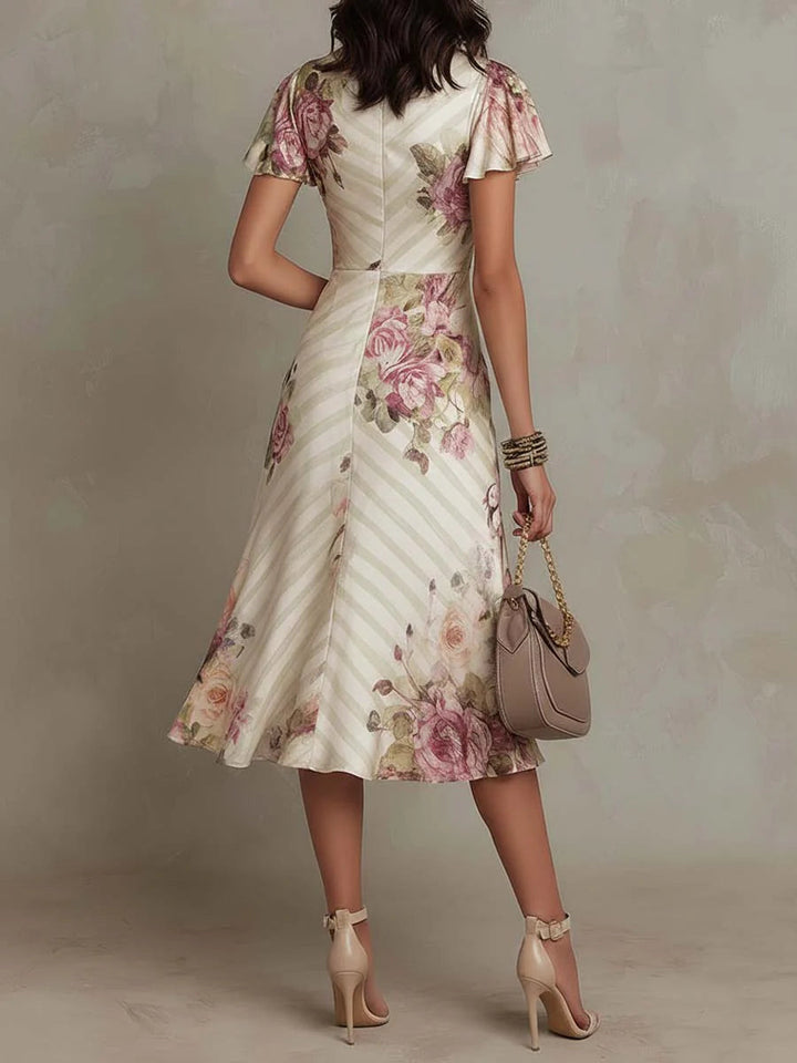 Flowy women's floral midi dress with a vibrant retro print, ideal for elegant occasions and summer fashion.