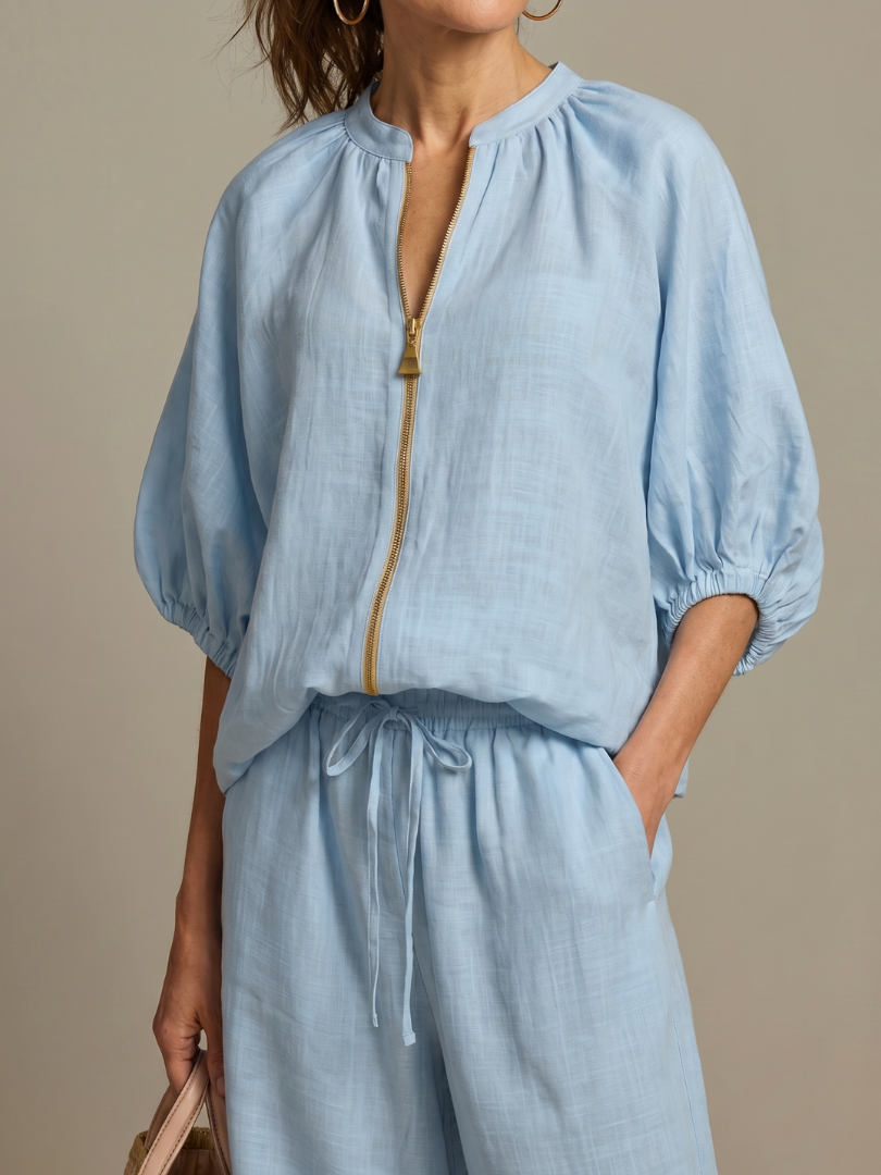 Versatile women's two-piece set featuring a zip front blouse and flowy wide-leg pants. Great for spring fashion.