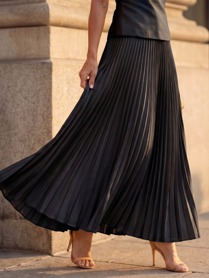 Elegant women's sleeveless two-piece set. Structured bodice paired with a graceful pleated skirt.