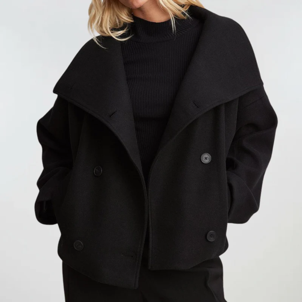 Women's cropped double-breasted coat with wide lapel. Chic modern outerwear for stylish women.