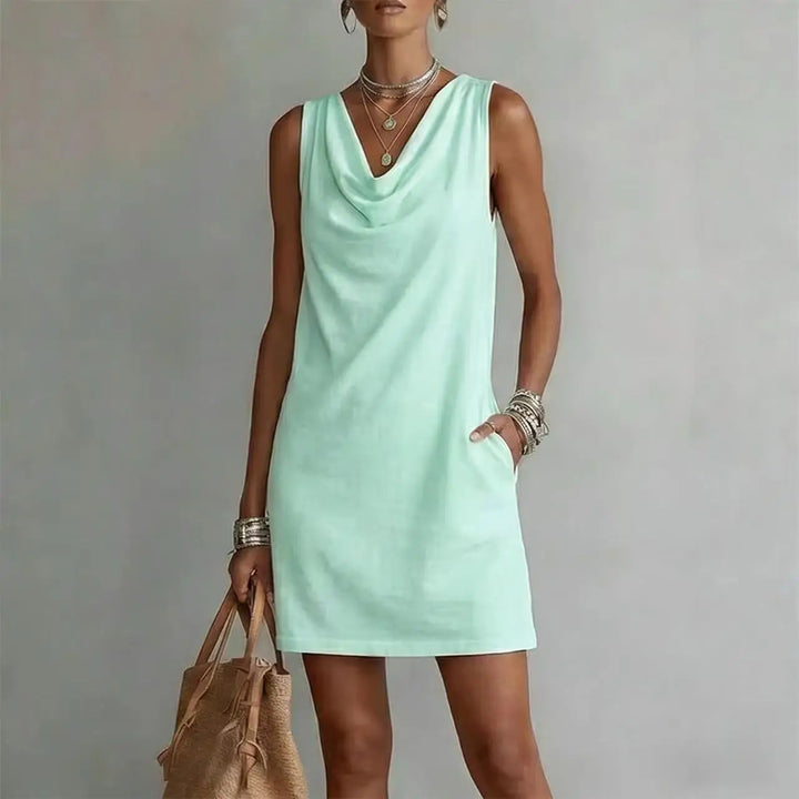 Stylish women's mini dress, cowl neck design, and functional pockets. Sleeveless, A-line for versatile fashion.