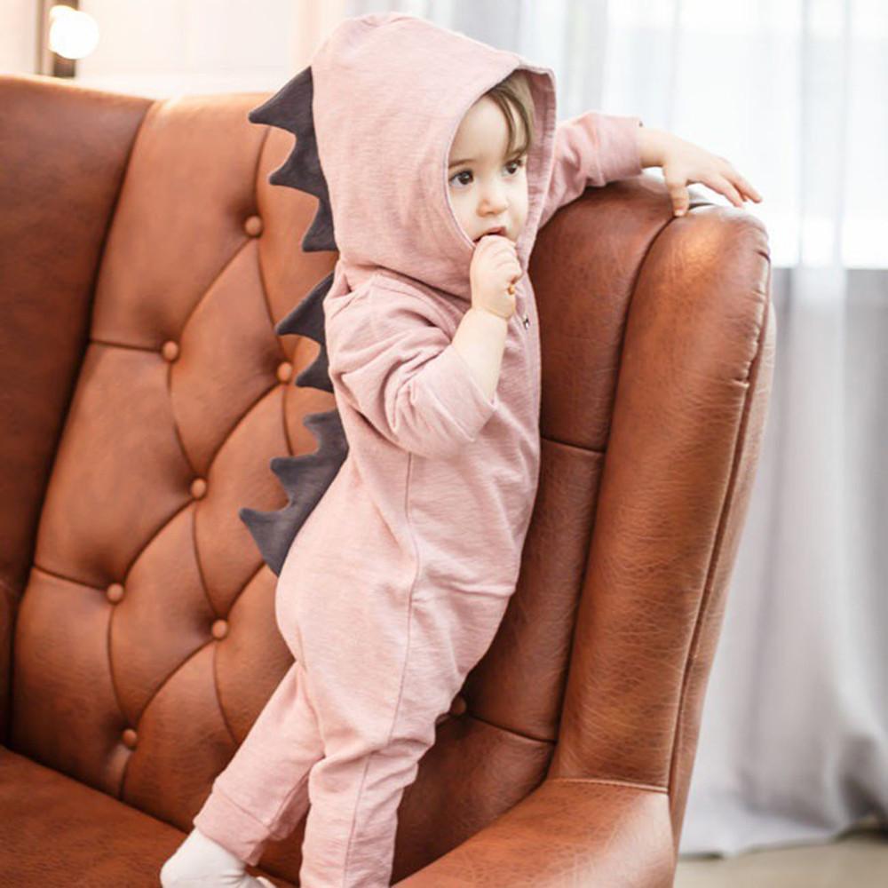 Pink baby dinosaur romper featuring playful 3D spikes. Soft and adorable infant onesie for girls.