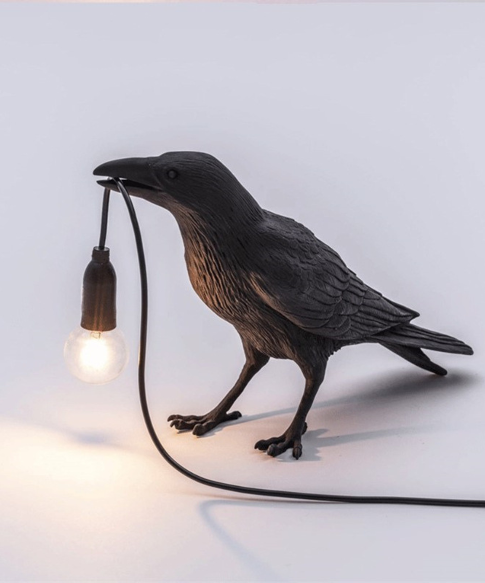 Artistic crow table lamp, a unique home accent. Black bird lamp design for modern desk lighting.