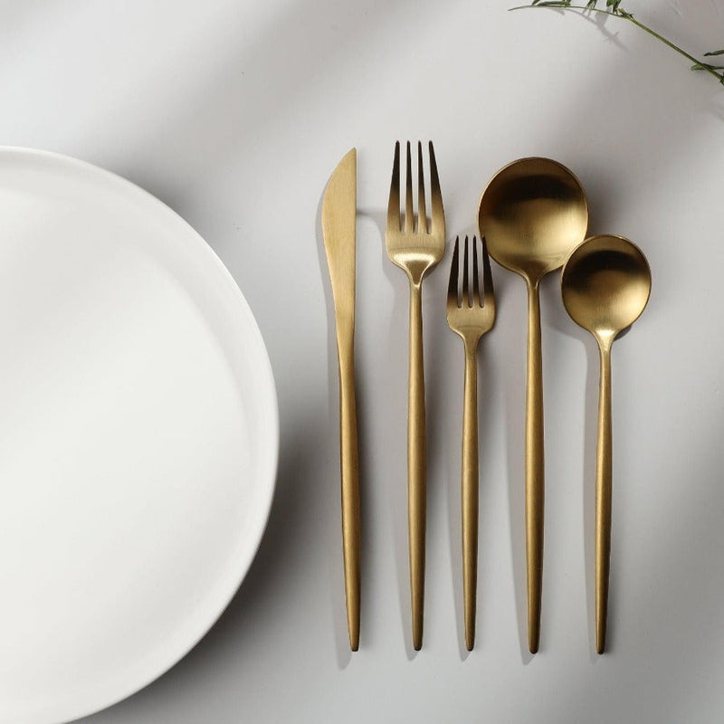 The Aurora Modern Cutlery Set displayed on a dining table, ready for use.