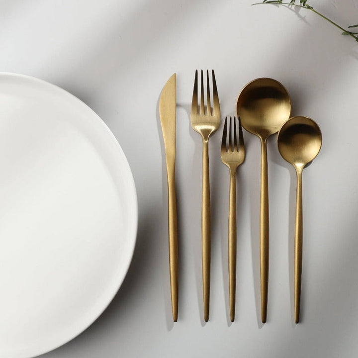 The Aurora Modern Cutlery Set displayed on a dining table, ready for use.