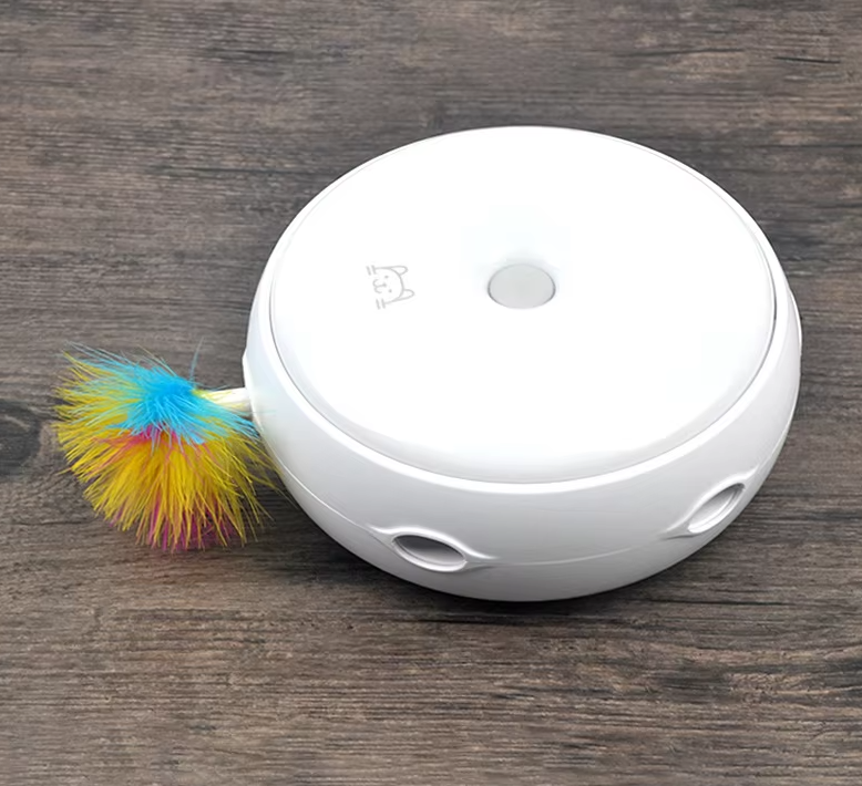 White automatic cat toy with a multi-colored fluffy feather, designed to stimulate a cat's hunting instinct.