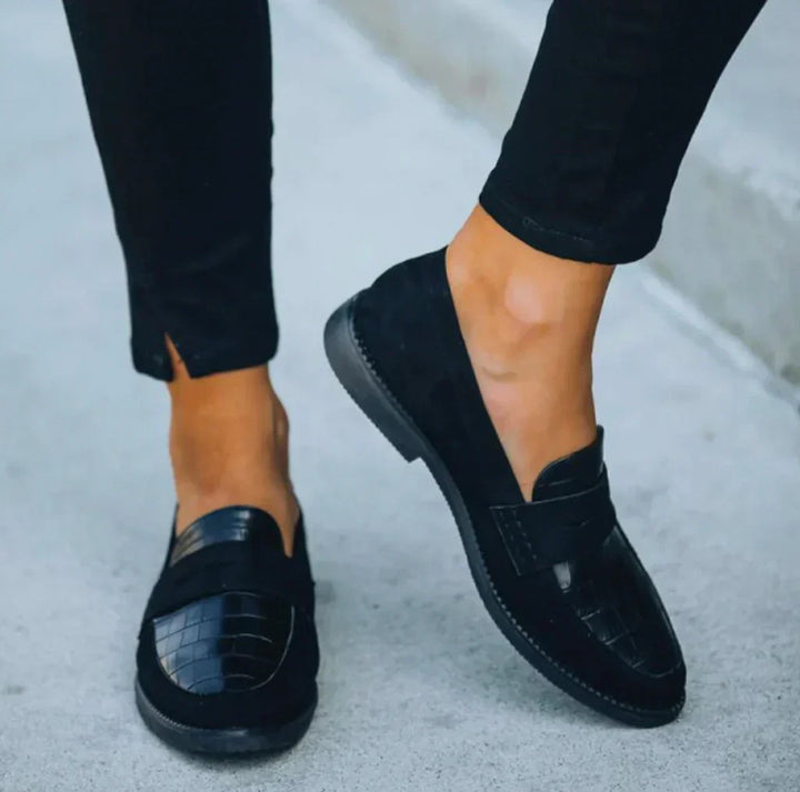 Black women's slip-on loafers with a distinctive croc-printed panel, ideal for everyday comfort & smart casual style.