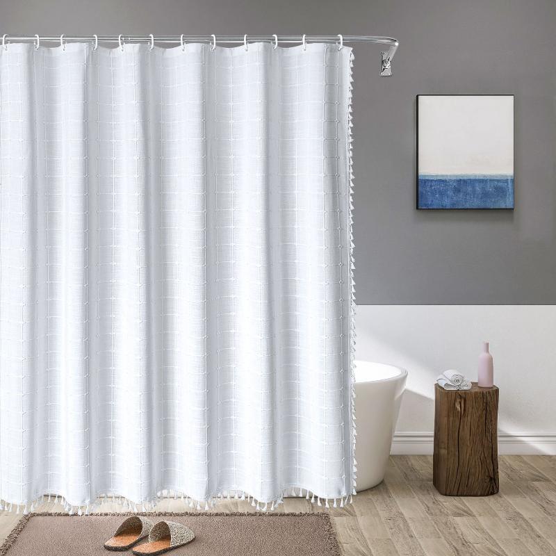 Detailed view of decorative tassels on a bohemian farmhouse linen waterproof shower curtain.