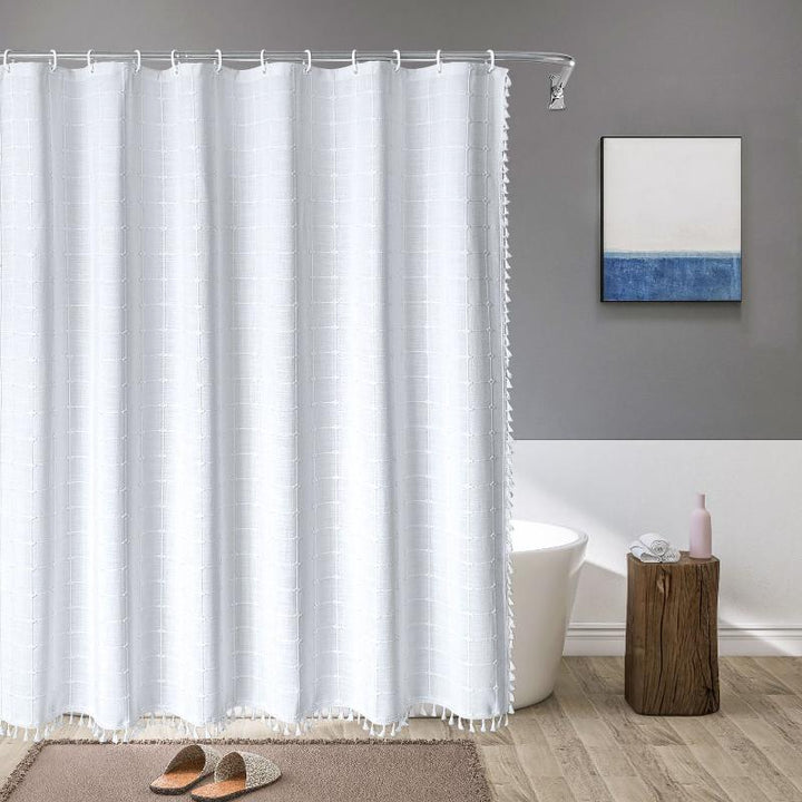 Detailed view of decorative tassels on a bohemian farmhouse linen waterproof shower curtain.