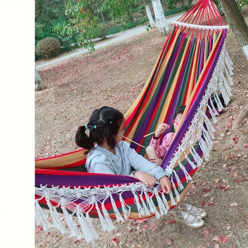 Indoor decor accent: Cozy striped cotton bohemian hammock with tassels. Enhance your relaxation space.