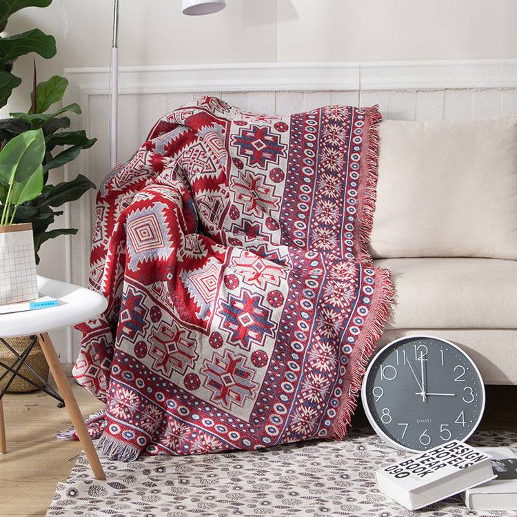 Knitted bohemian throw, cozy cotton blend with decorative tassels.