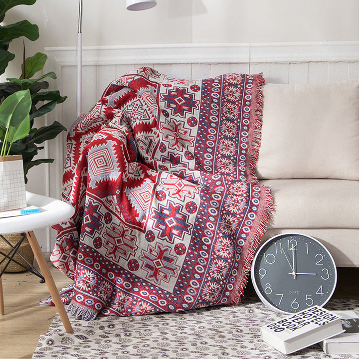 Knitted bohemian throw, cozy cotton blend with decorative tassels.