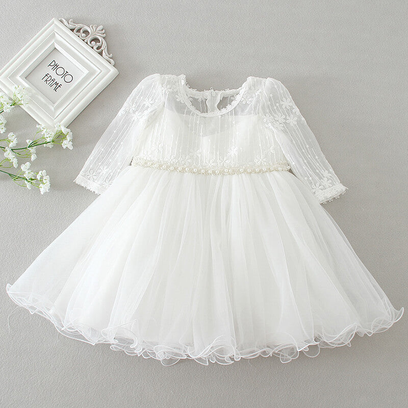 Stylish girls' polka dot tulle dress with a full skirt, perfect for a charming ceremony or special occasion.