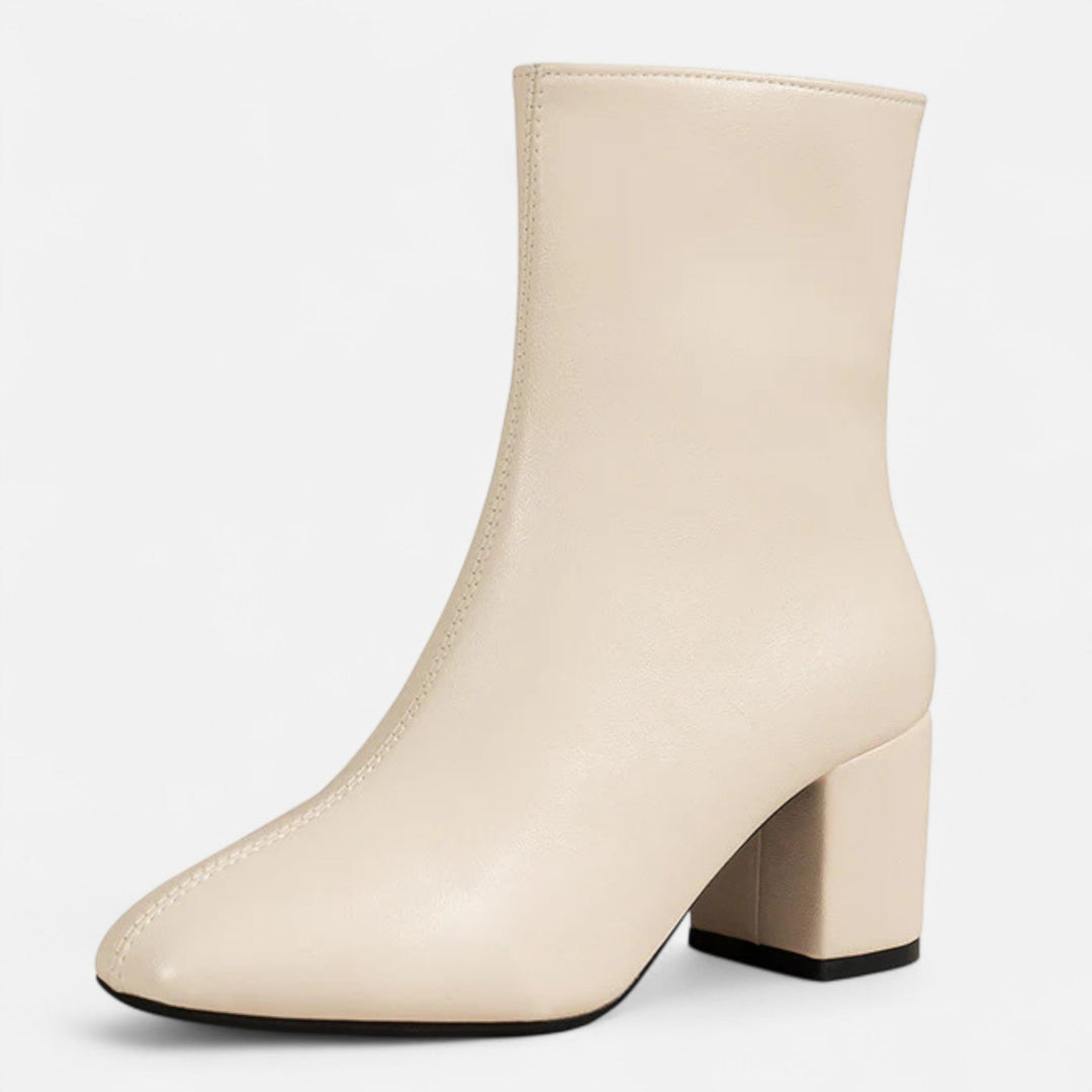 Woman showcasing chic block heel ankle boots, ideal for stylish fall fashion and comfortable everyday elegance.