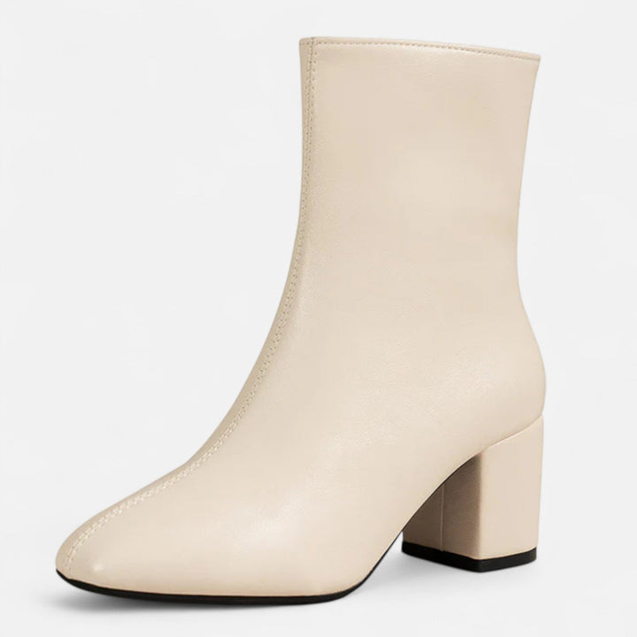 Woman showcasing chic block heel ankle boots, ideal for stylish fall fashion and comfortable everyday elegance.