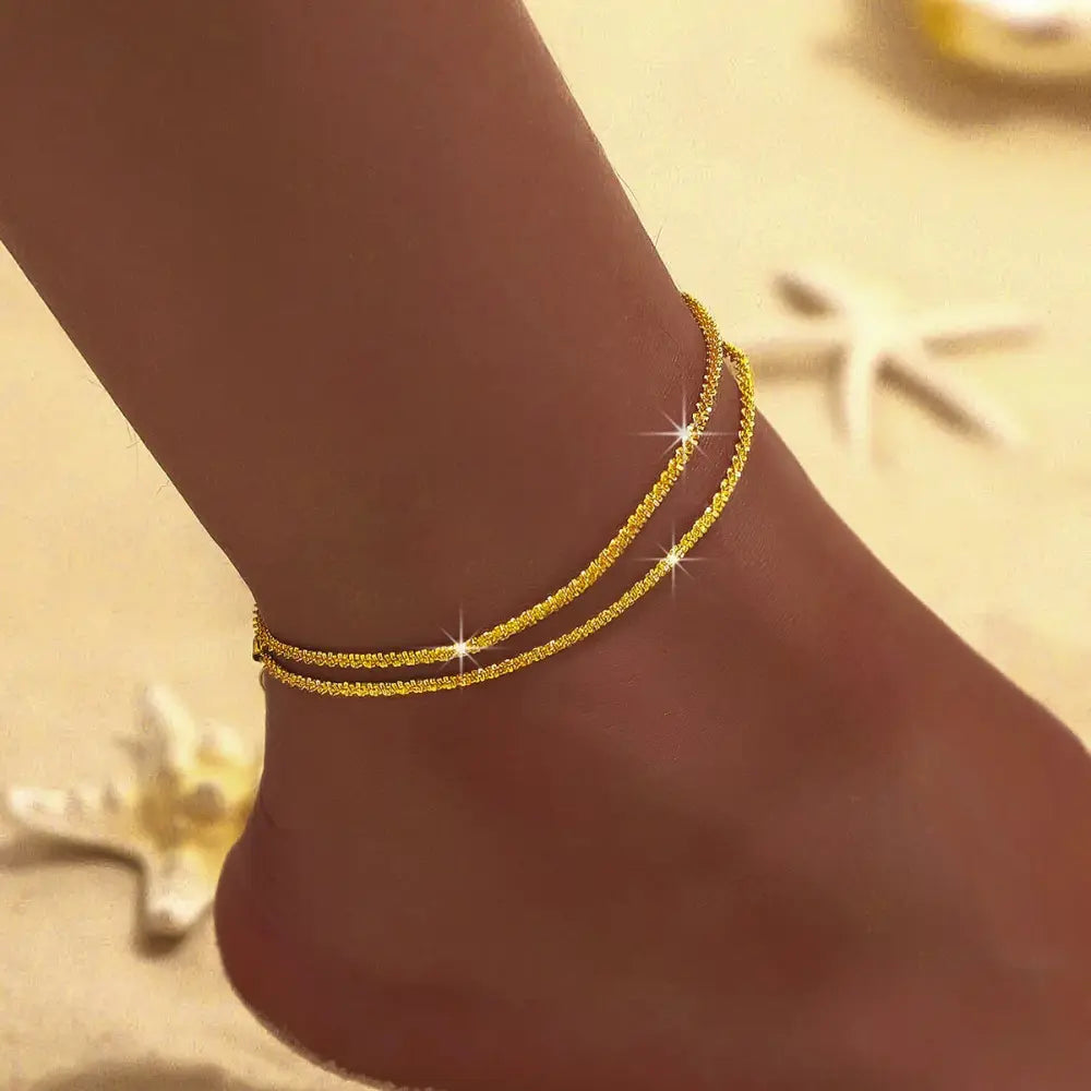 Chic women's double ankle bracelet in delicate silver & gold. Elegant fashion accessory for a stylish look.