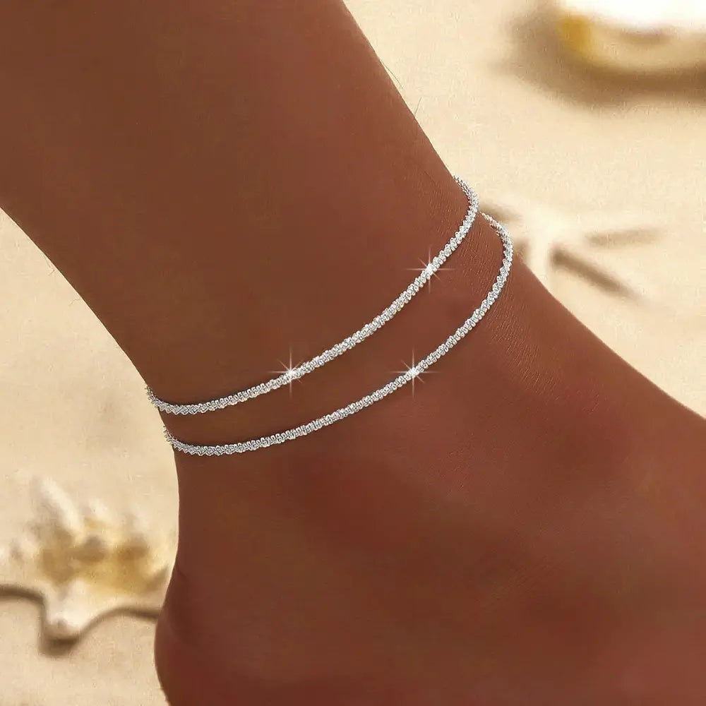 Women's chic double ankle bracelet featuring silver & gold. Elegant and delicate fashion accessory jewelry.