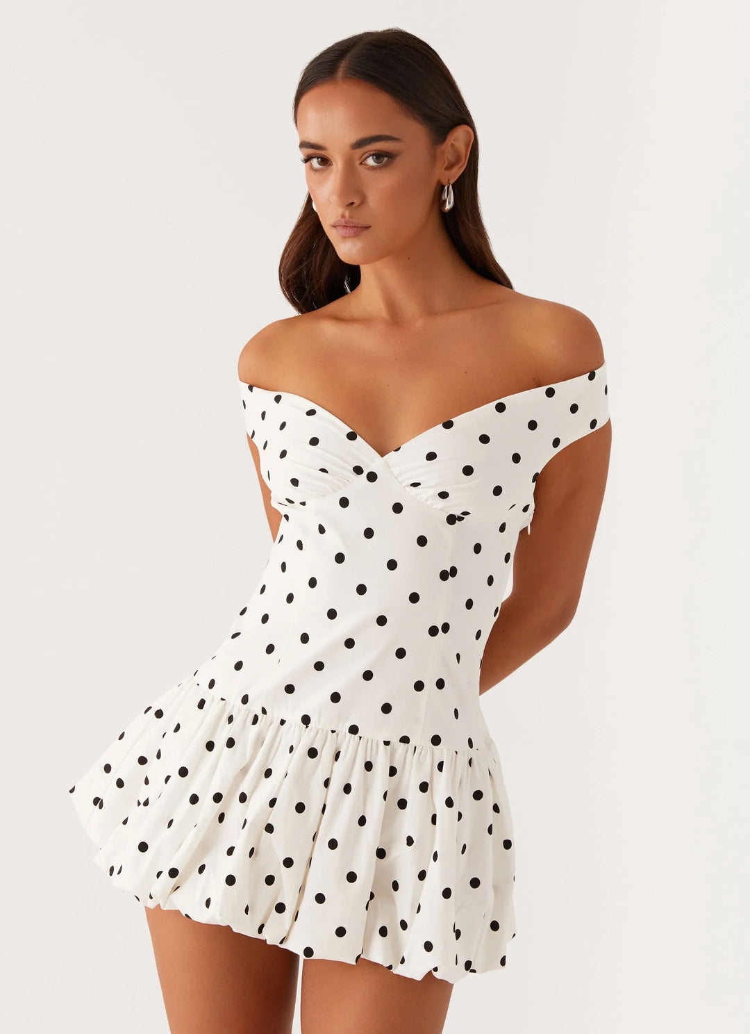 Flirty off-shoulder polka dot mini dress with peplum detail. Ideal summer party dress for women.