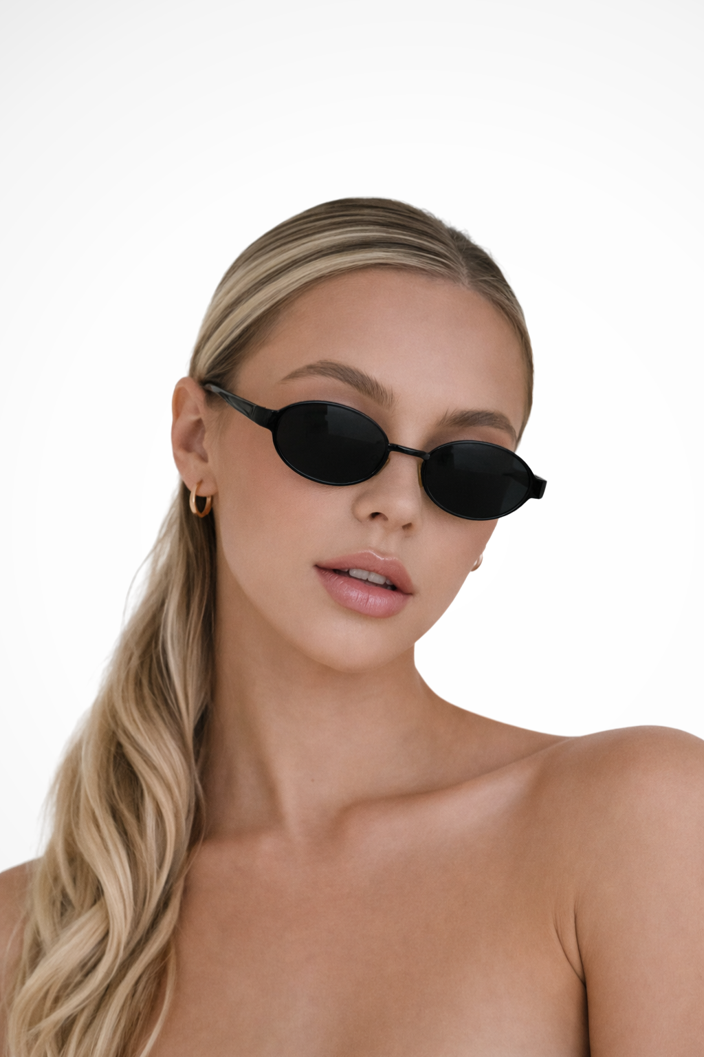 Women's sleek oval metal frame sunglasses featuring stylish tinted lenses. A modern fashion accessory.
