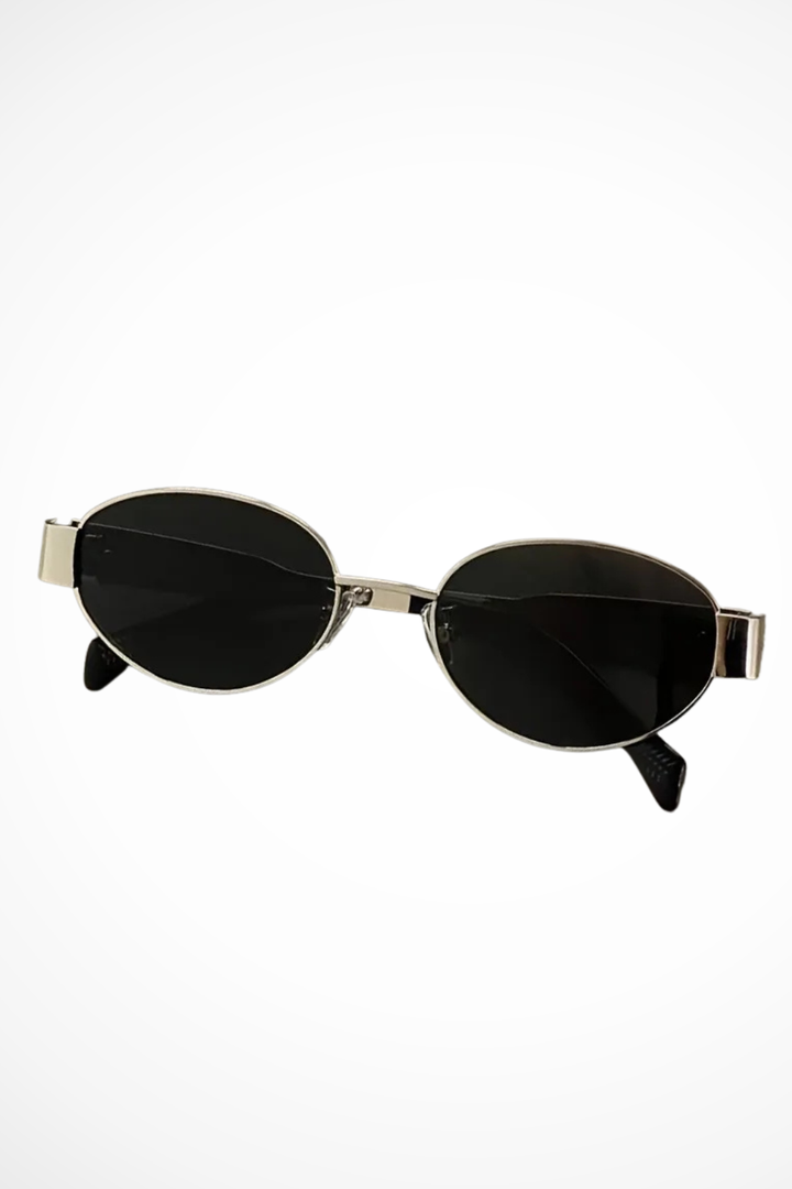 Elegant women's oval sunglasses featuring a slender metal frame and protective tinted lenses. Chic eyewear.
