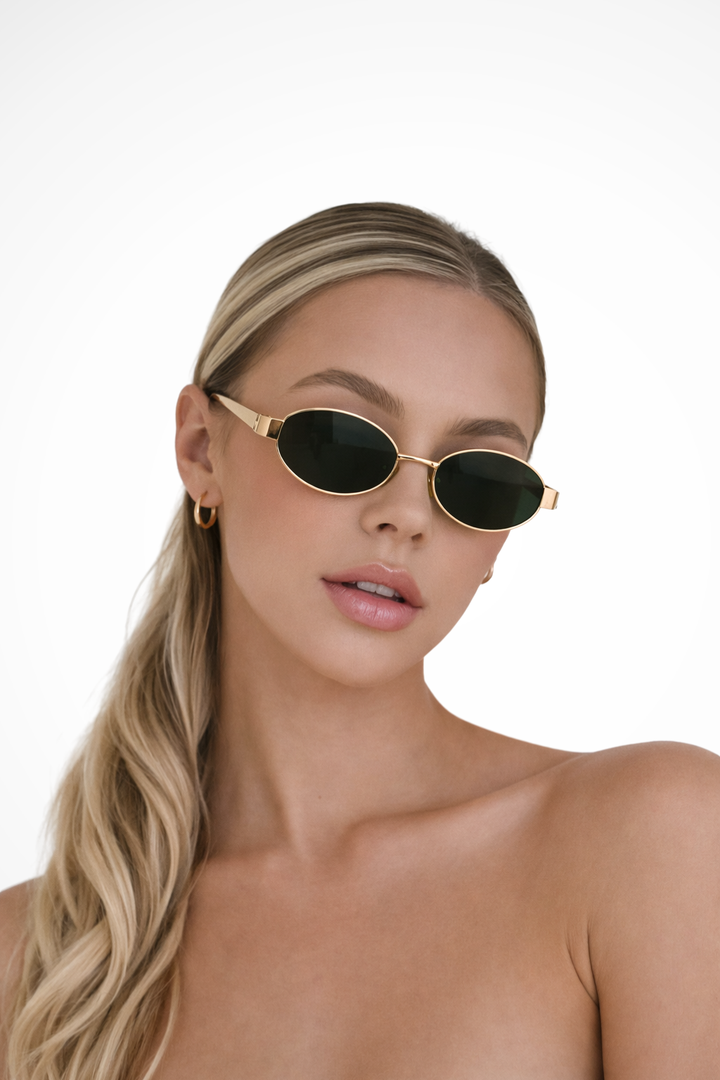 Minimalist women's oval metal frame sunglasses with tinted lenses. Ideal for a chic and fashionable look.