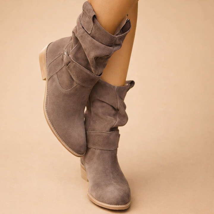Close-up of chic women's slouch ankle boots, highlighting the elegant buckle and textured design. Winter-ready.