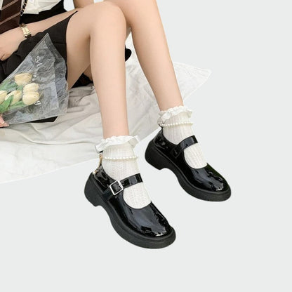 Stylish women's black Mary Jane flats with a shiny finish and a functional adjustable strap