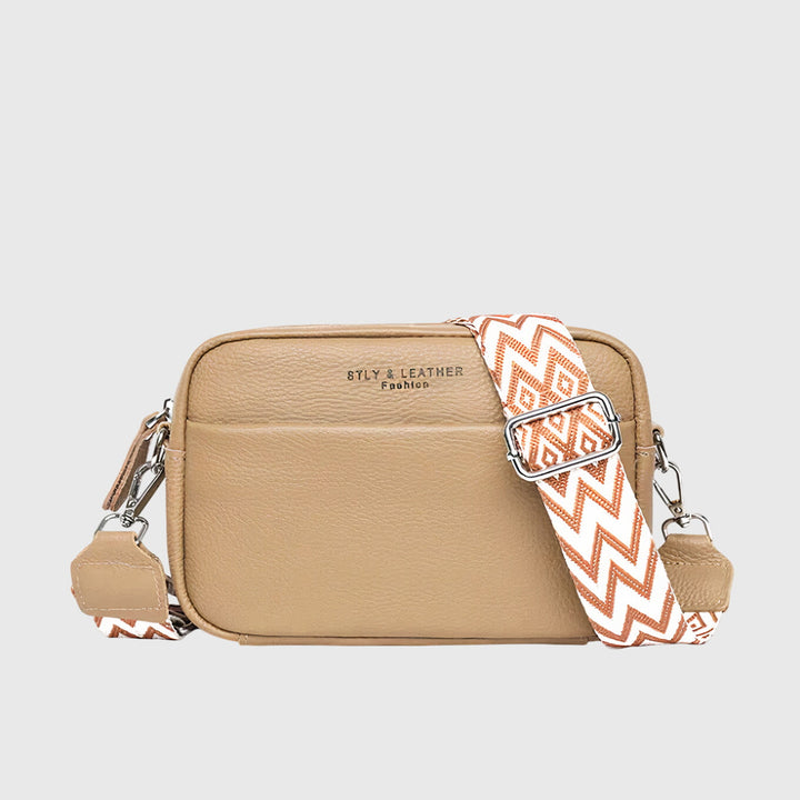 Close-up of a women's classic black crossbody bag, showcasing textured material and refined hardware.