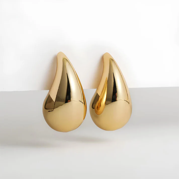 Close-up of elegant gold dangle drop earrings, perfect women's fashion jewelry.