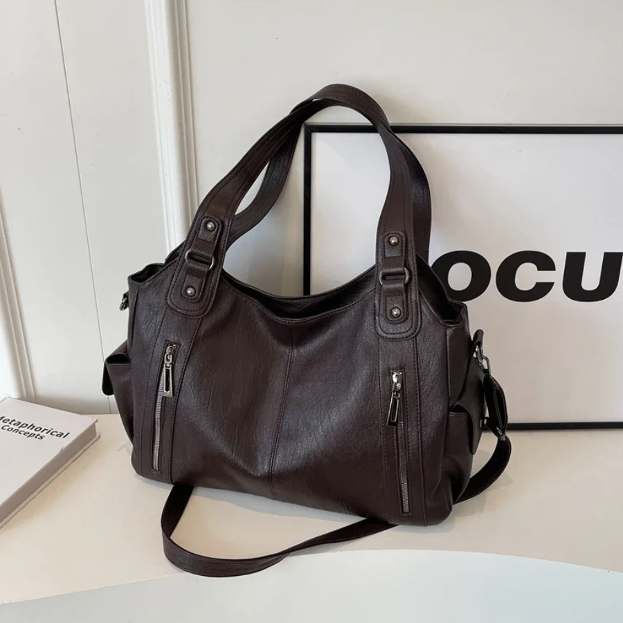 Side profile of a cognac vegan leather shoulder bag, compact yet roomy for essentials