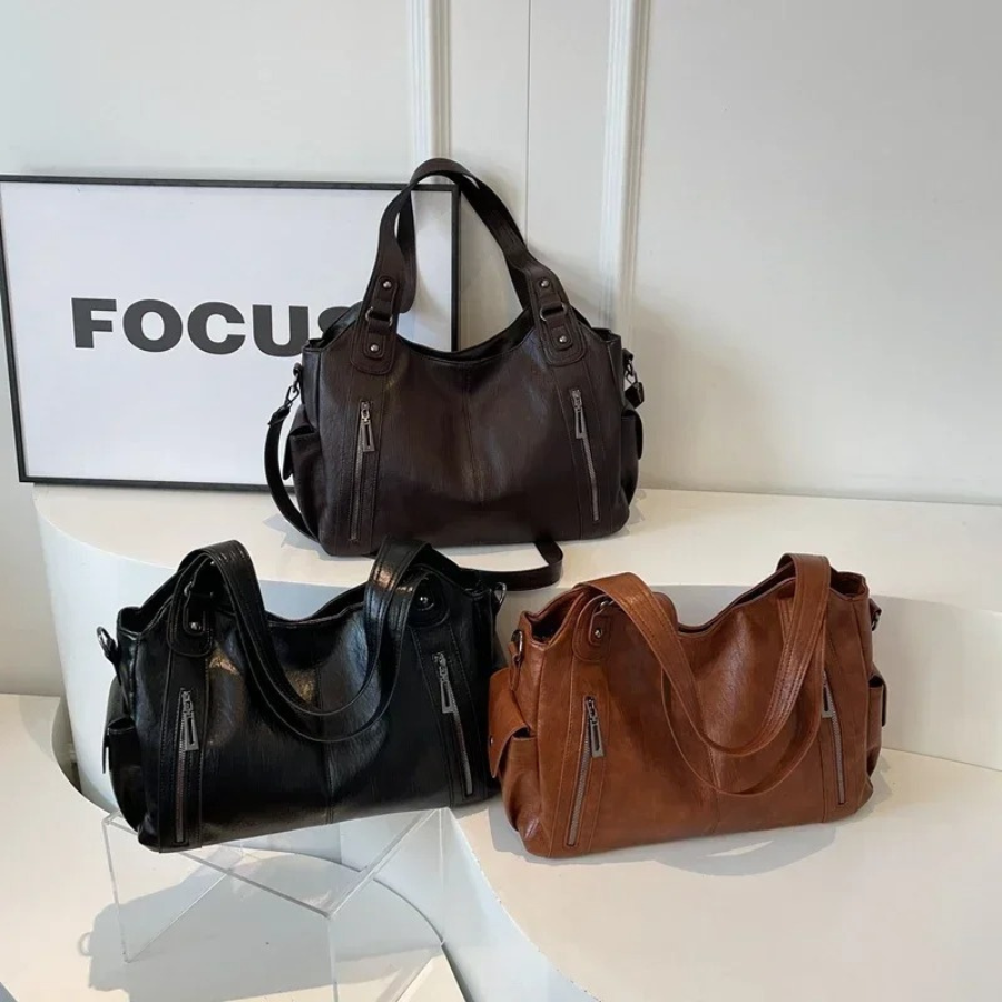 Black vegan leather shoulder bag with a subtle logo detail, sophisticated women's handbag