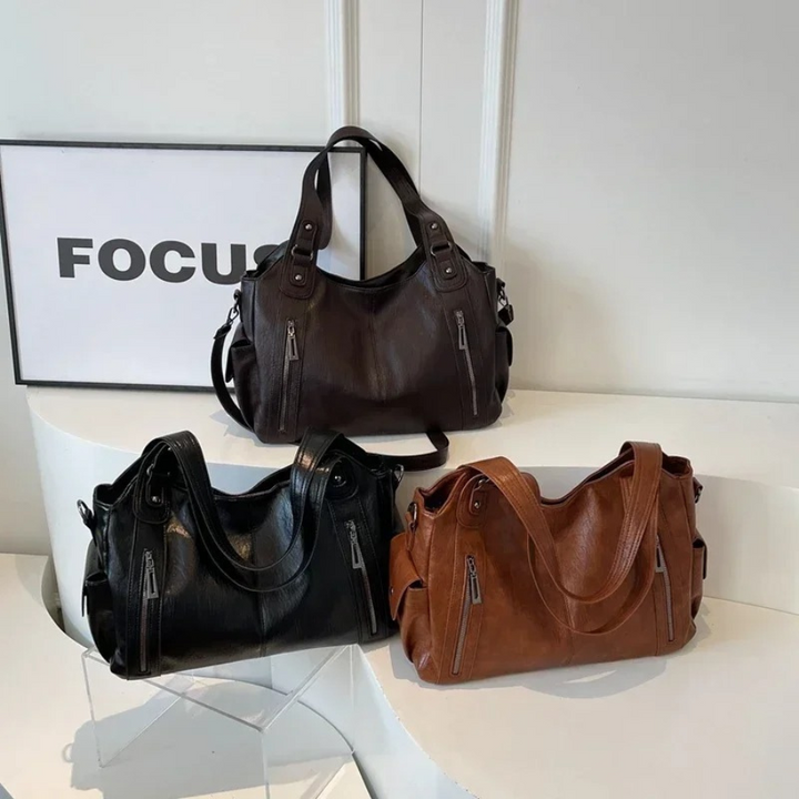 Black vegan leather shoulder bag with a subtle logo detail, sophisticated women's handbag