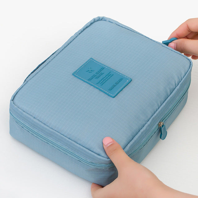 Portable travel beauty bag for women, waterproof, with a dark blue floral design.