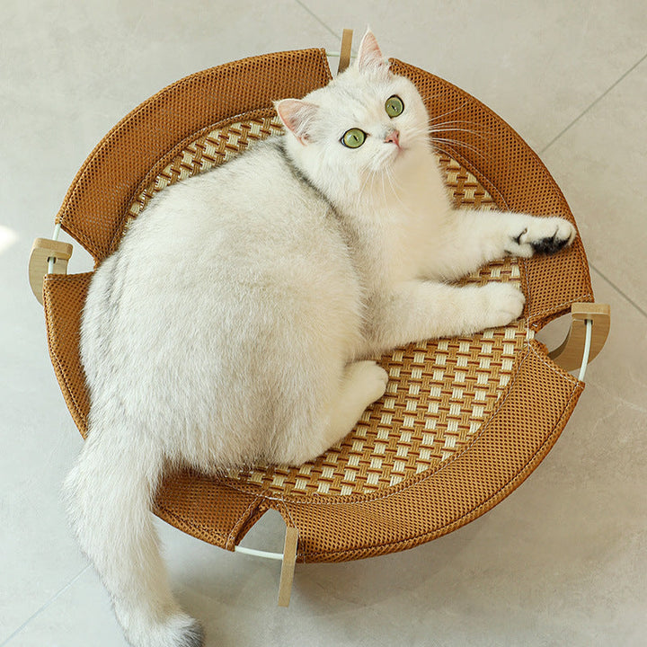 Cat enjoying a cool rattan hanging mat. Perfect elevated summer cat bed for ultimate pet comfort.