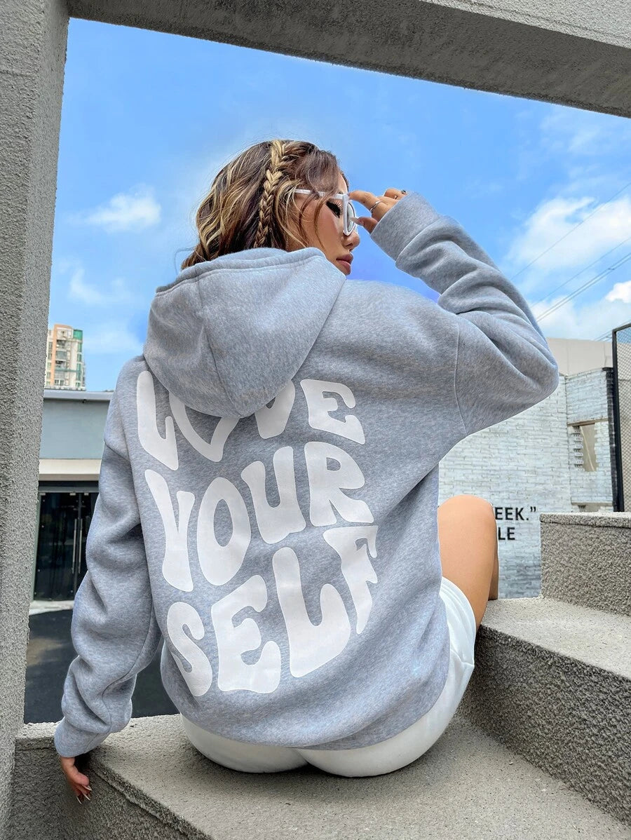 Relaxed fit women's cozy hoodie in a neutral color, featuring an adjustable drawstring and large pocket.