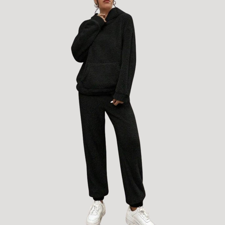 Full-length view of a women's cozy loungewear set, including a hooded top and black lounge pants.