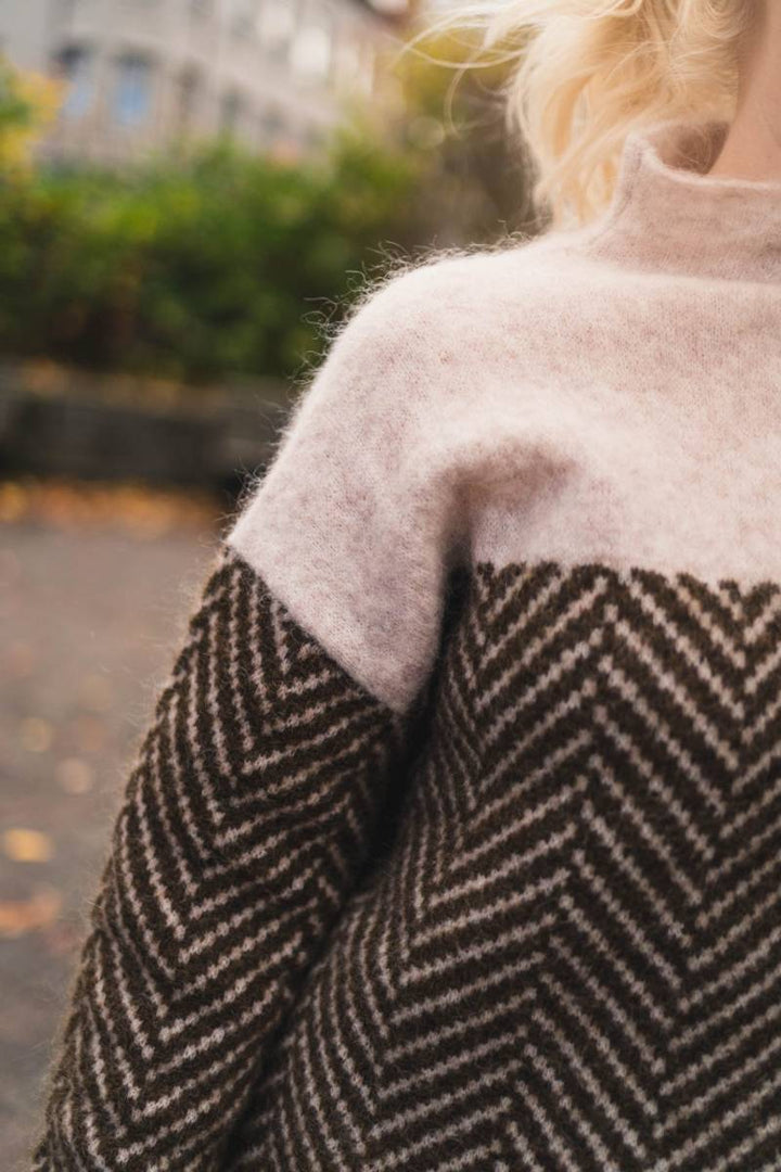 Stylish women's loose fit high collar knit sweater in a neutral tone, great for winter outfits.