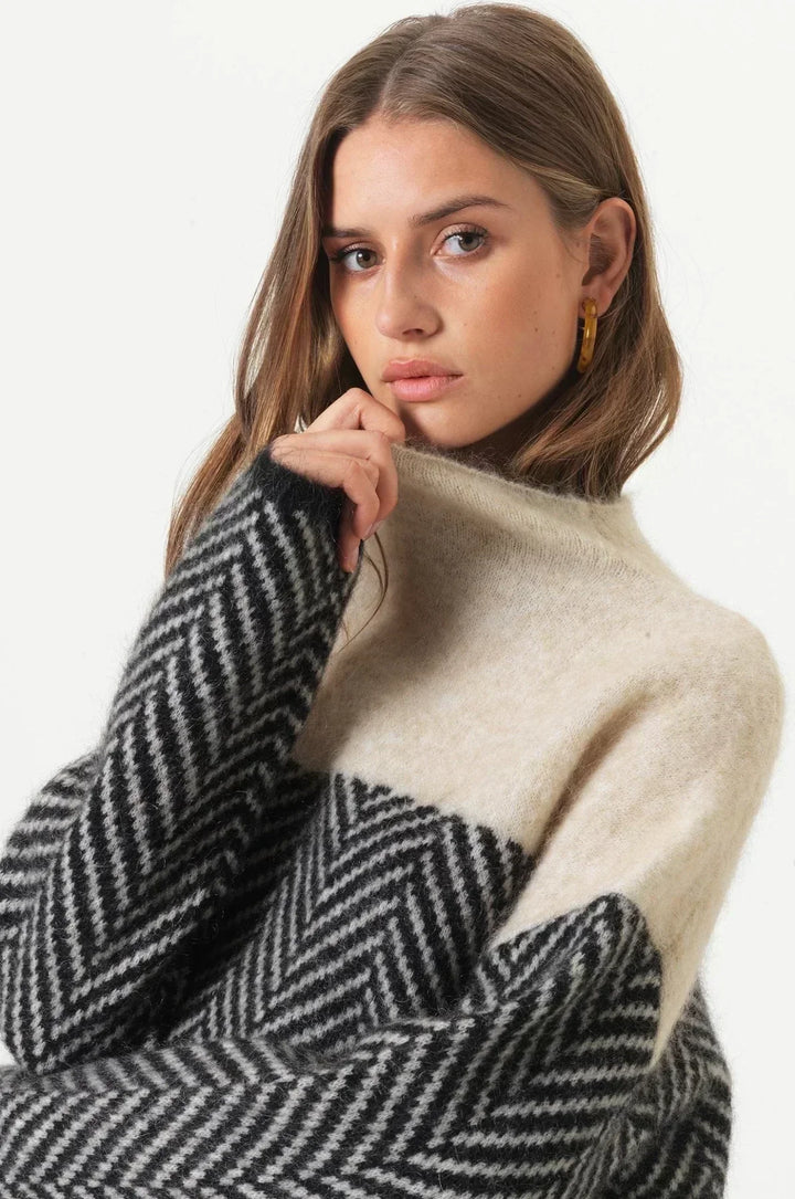 Full shot of a comfortable women's high collar knit pullover, showcasing its loose fit and winter style.