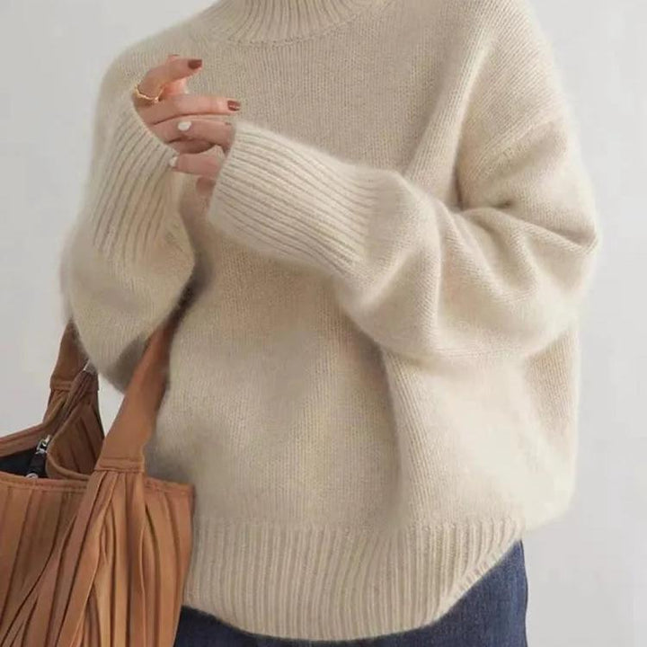 Model wearing a beige oversized turtleneck knit sweater, showcasing its cozy fit.