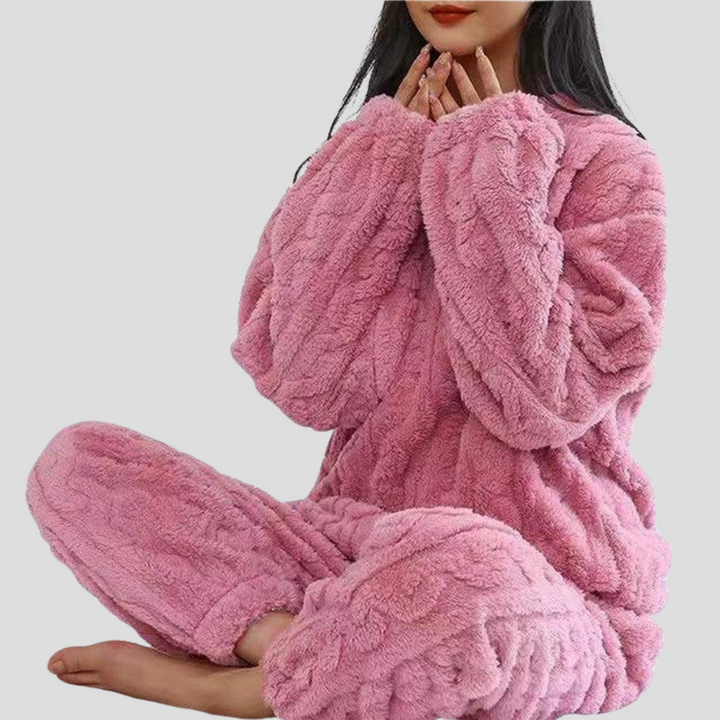 Woman smiling, wearing a warm women's fleece pajama set, showcasing comfortable sleepwear