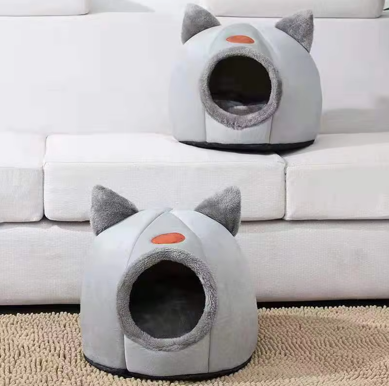Happy cat snuggled in a cozy, warming cat-shaped bed with a soft, removable cushion.