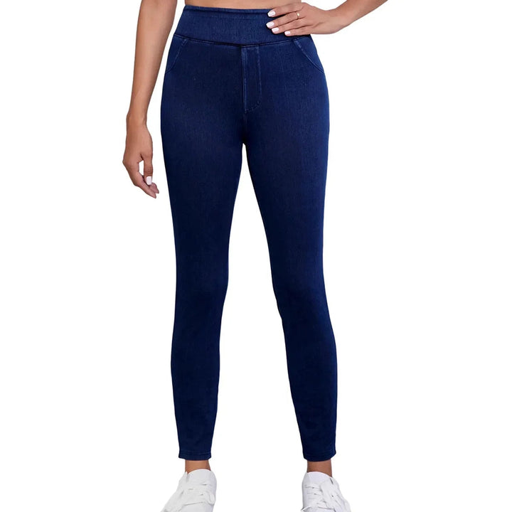 Detail of the high-rise waist and slim fit cut on women's dark blue stretch denim jeans.