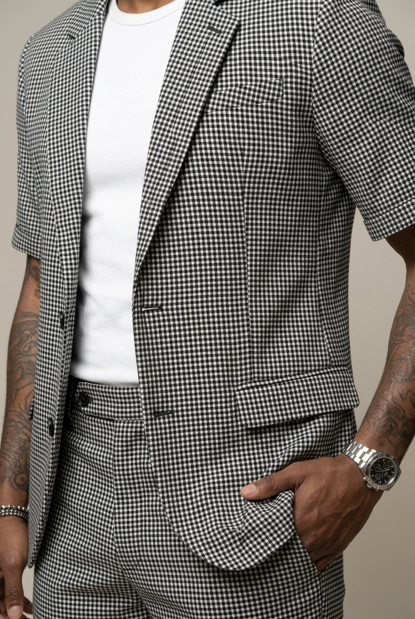 Stylish men's contemporary black check two-piece suit set with a modern blazer and smart shorts ensemble.