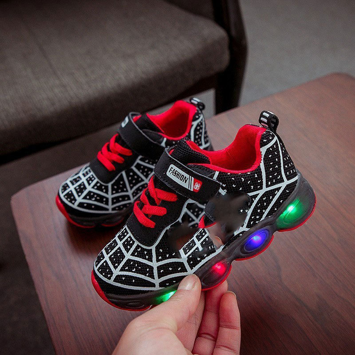 Fun superhero LED sneakers for kids, featuring light-up soles & secure velcro straps for playful adventures.