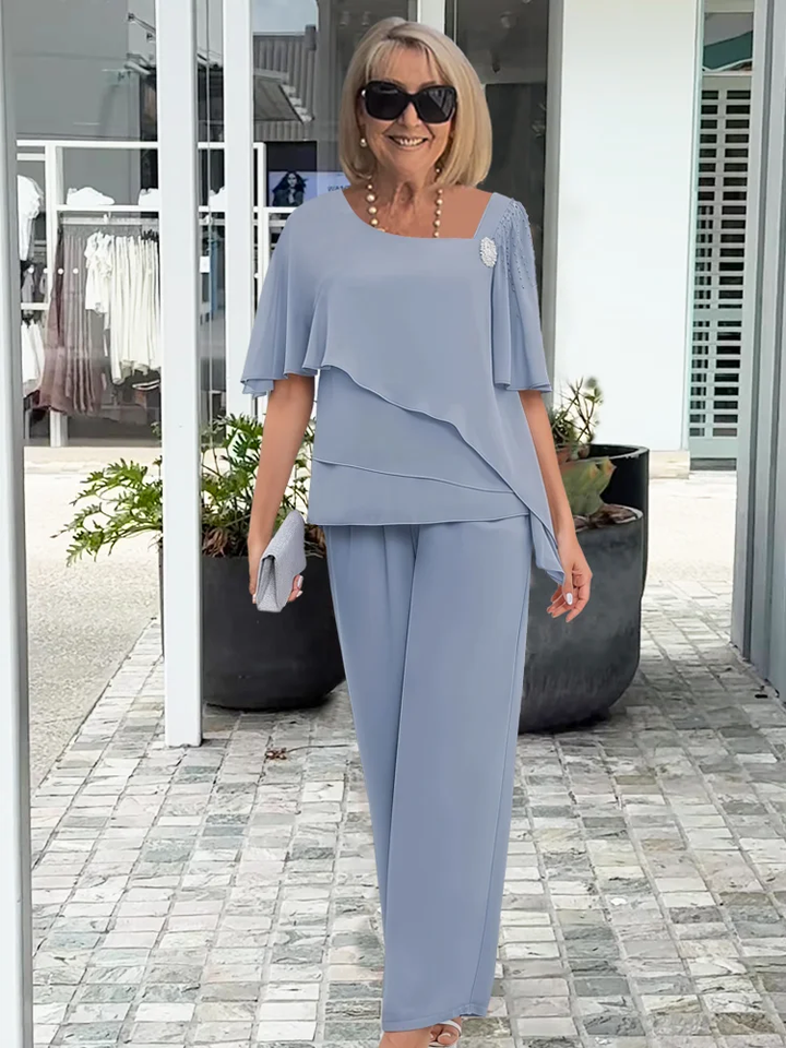 Casual elegant women's lounge set with an asymmetric cut top & wide-leg pants, perfect for warm weather.