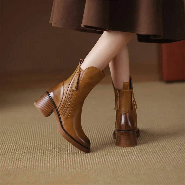 Close-up of women's elegant black ankle boots, showcasing streamlined design and quality footwear.