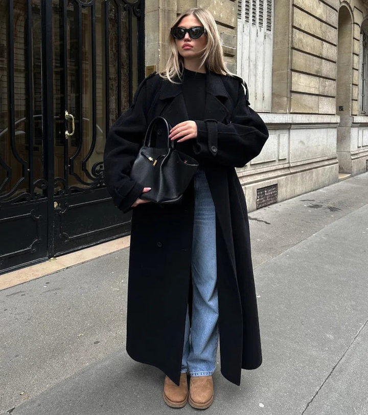 Elegant black double-breasted trench coat for women with classic styling, ideal for winter or autumn.