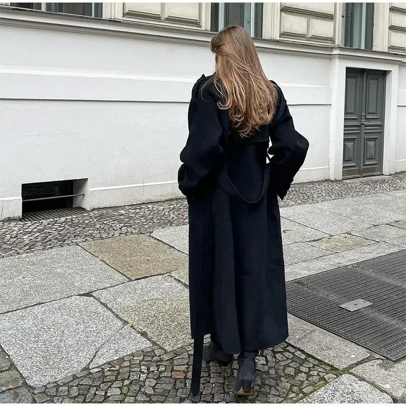 Chic black double-breasted trench coat, featuring a belted waist and structured design, for a sophisticated look.