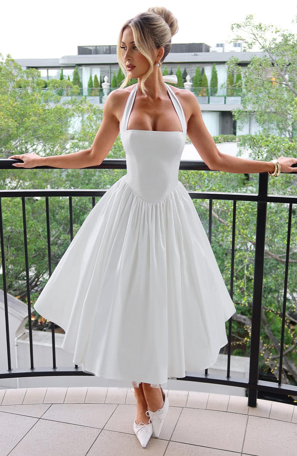 Elegant black halter neck midi dress for wedding guests, front view, in studio.