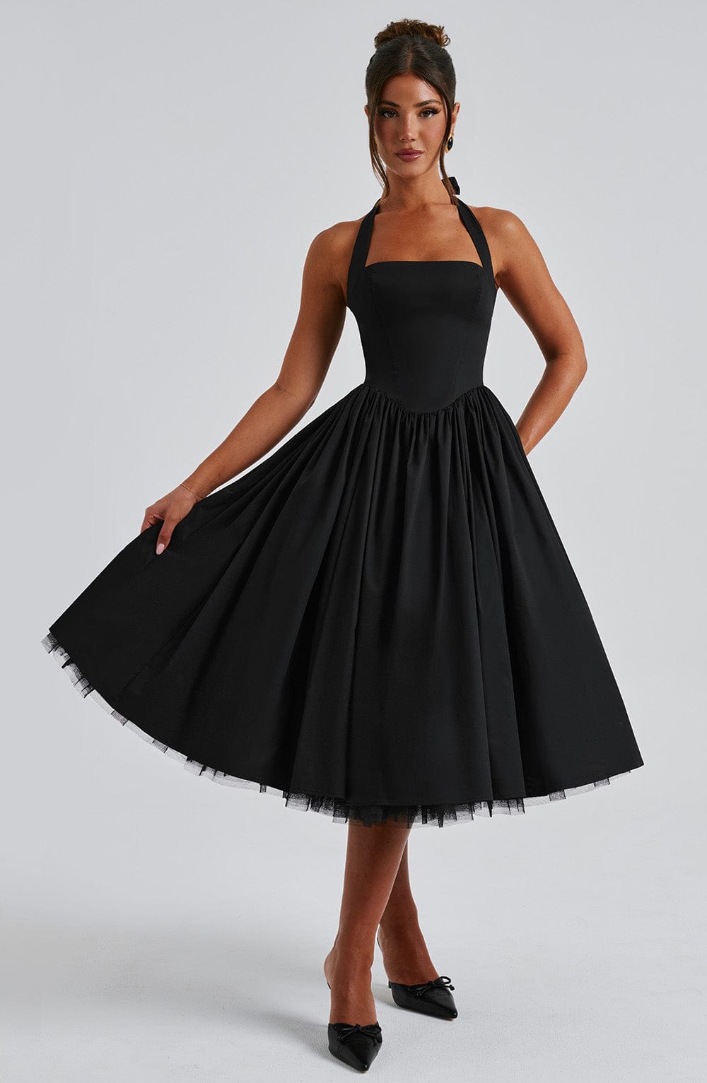 Black elegant midi dress, halter style, showcasing the fabric texture and drape.